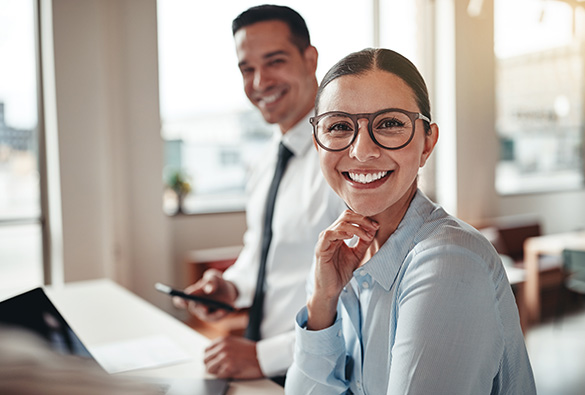 Smiling colleagues working in a bright office space.