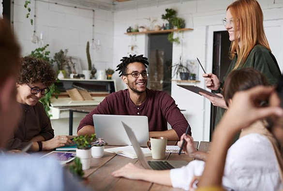 Group of people having a meeting in a modern office with plants.
