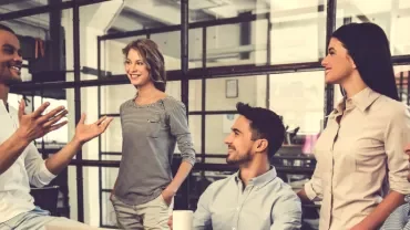 Group of colleagues having a discussion in an office setting.