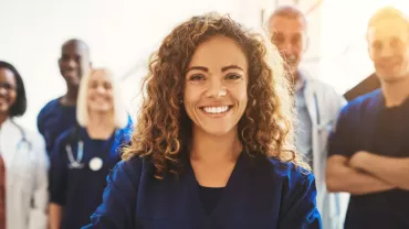 Smiling healthcare professionals standing together in a bright room.