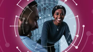 Two people smiling in a modern office setting with a circular graphic overlay.