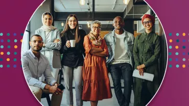 Group of six people smiling in a modern office.