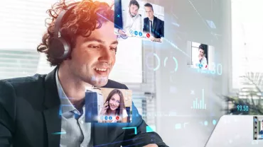 Person in a virtual meeting using a laptop with multiple video call screens.