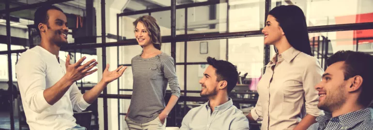 Group of colleagues having a discussion in an office setting.