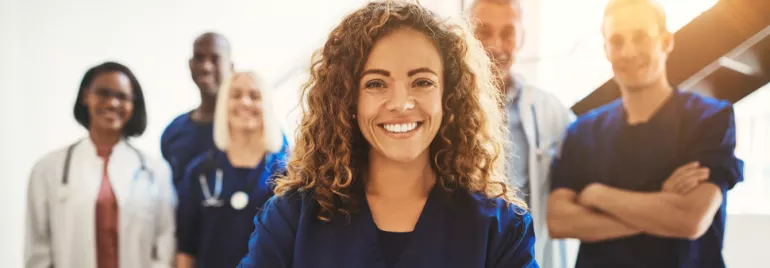 Smiling healthcare professionals standing together in a bright room.