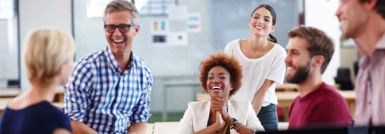 Group of people in an office laughing and talking.