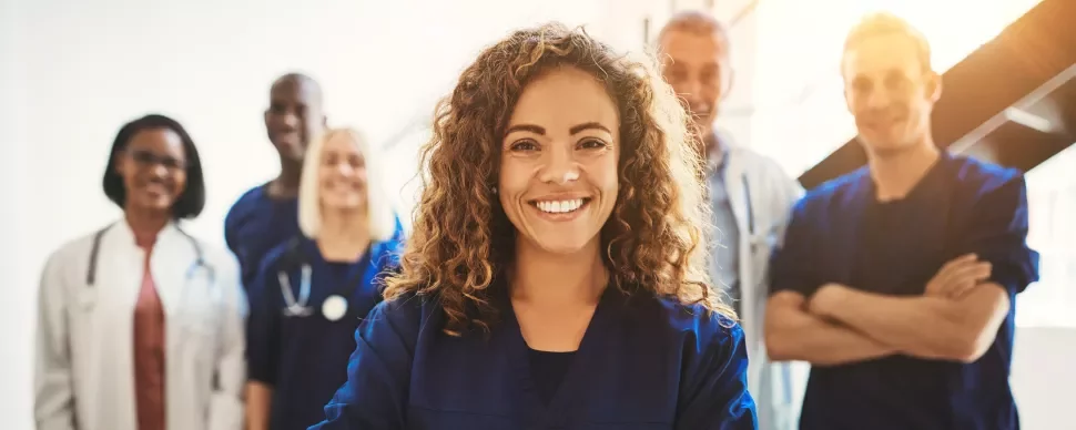 Smiling healthcare professionals standing together in a bright room.