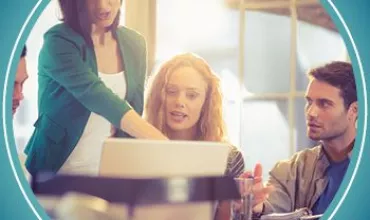 A group of people collaborating at a desk with a laptop.