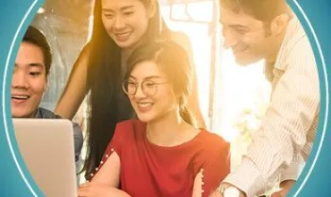 Group of people happily collaborating on a laptop.