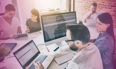 People working together at computers in a modern office setting.