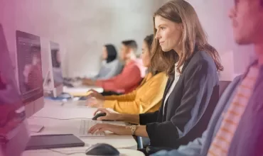 People working at computers in a modern office space.