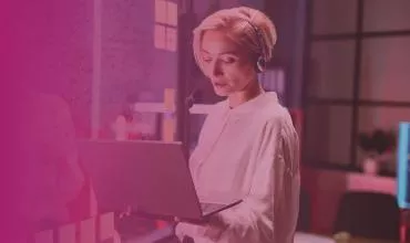 Person with headset using a laptop in a modern office.